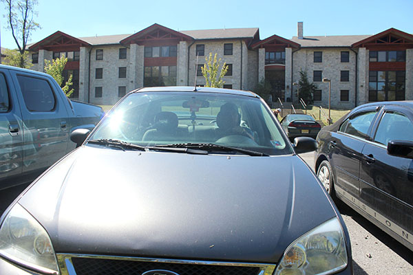 Sophomore Matt Miksich pulling out of a parking space at the Living/Learning Center with his parking pass hanging from his rearview mirror. 