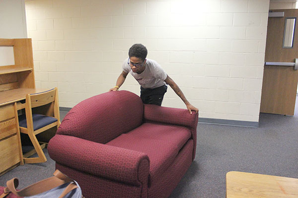 Sophomore TJ Mitchell-Scott moves furniture in Foxfire Lodge.