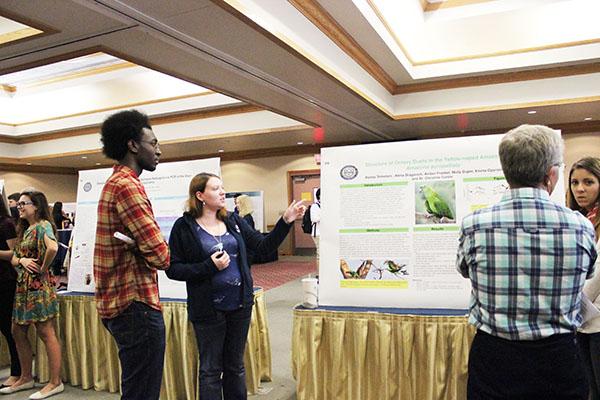 Student Elijah Lawrence interacts with a researcher on her project on duets in a tropical parrot.