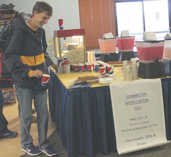 Sophomore Michael Mastovich grabs a cup of popcorn inside the Zone arcade in the Student Union during Commuter Appreciation Day last Wednesday.