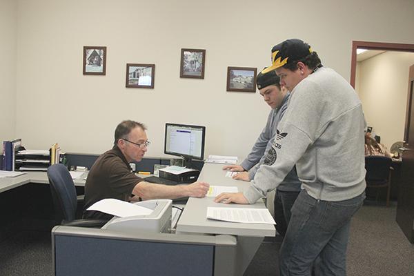 Registrar employee George Hancock (left) helps junior Zach Barbus (middle) and sophomore David Seifert (right) withdraw from classes. 