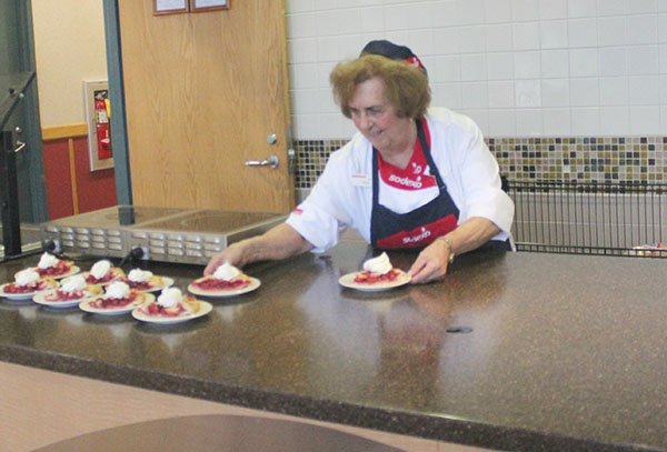 Sodexo employee Helen Ferra placing desserts in the Varsity Cafeteria