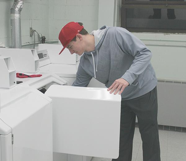 Freshman John McGinley puts laundries in a dryer in Hickory Hall’s laundry room. 