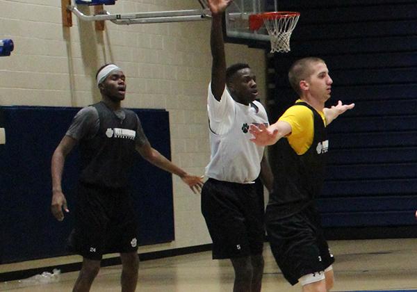 Freshman guard Olando King Jr. (center) attempts to avoid defenders senior guard Nate Snodgrass (right) and sophomore forward Levi Masua (left) during practice last week.