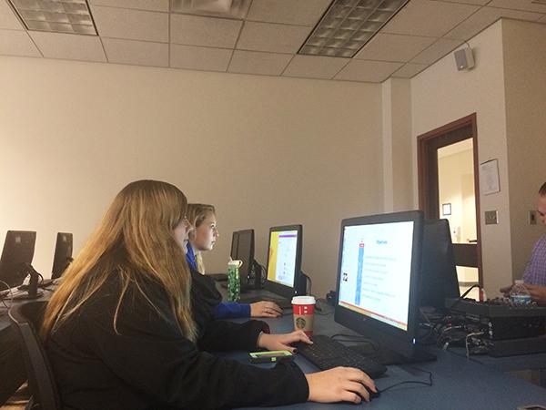Left to right, seniors Chelsey Berkebile and Mariah Dickert open up PowerPoint to follow along with notes for their Graphic Design class.
