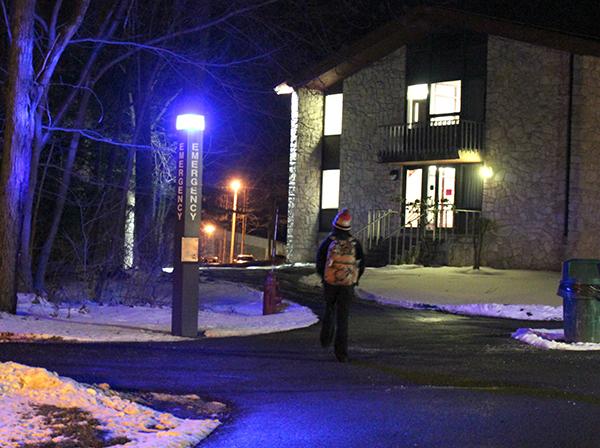 Student Stephanie Bonga walks along a path outside Maple Hall.