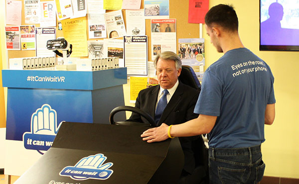 AT&T Employee Zack Smith (right) tells Sen. John Wozniak (left)  how the texting and driving simulator works.  