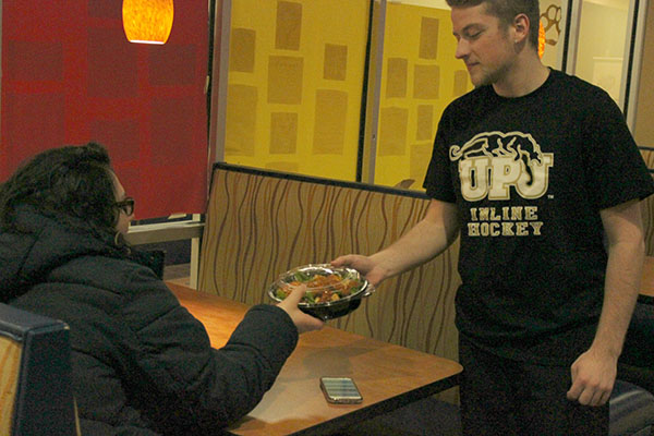 Sodexo employee Eric Brimmeier (right) delivers food to Jewlee Romani at Mountain Cat Club on Feb. 4. 