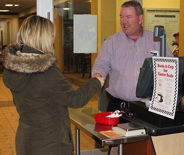 Sodexo General Manager Kevin Dicey (right) works the register in the Tuck Shop as senior Liz Lischick makes a purchase. 