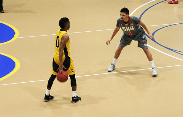 Pitt-Johnstown Sophomore guard Dale Clancy on offense Saturday night in the Sports Center against a Seton Hill University defender during the first-round playoff game. 