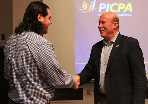 Junior Jason Wallace, president of Pitt-Johnstown’s Accounting and Finance Interest Group, shakes hands with Pennsylvania Institute of Certified Public Accountants CEO Michael Colgan. 