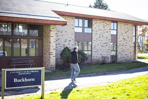 Senior Alex Taylor walks past Buckhorn Lodge, which is set to be renovated over the summer.