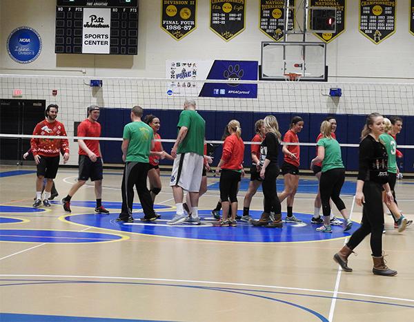 Participants of the students vs. staff volleyball game shake hands after the students defeated the staff 2-1. 