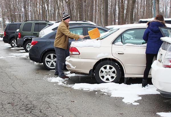 Junior Bradley Springer and non-student Heather Walker clean off a car at the North lodges’ parking lot. 