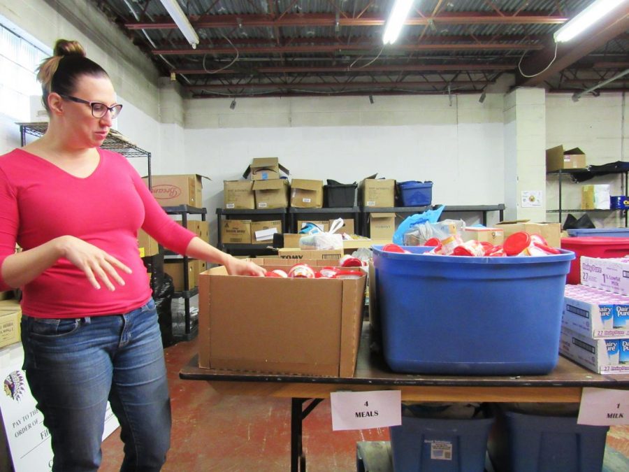 Natalie Kauffman, who coordinates the Cambria County Backpack Project, explains the assembly line that volunteers use to pack the backpacks each Monday night.