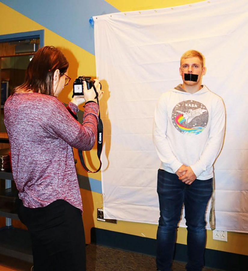 Sophomore Kayla Johnson takes a photograph of freshman Ben Nogroski at the Mt. Cat Club for a No Hate Photo Shoot sponsored by Alliance Club members.