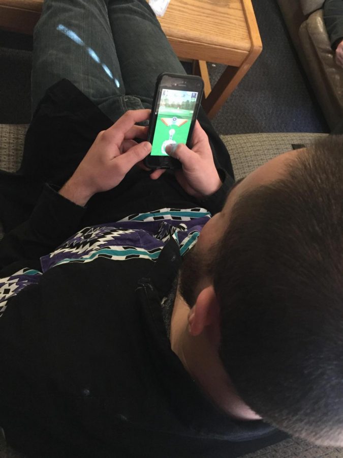 Senior Jake Hofer play on his cell phone in a Willow apartment. 