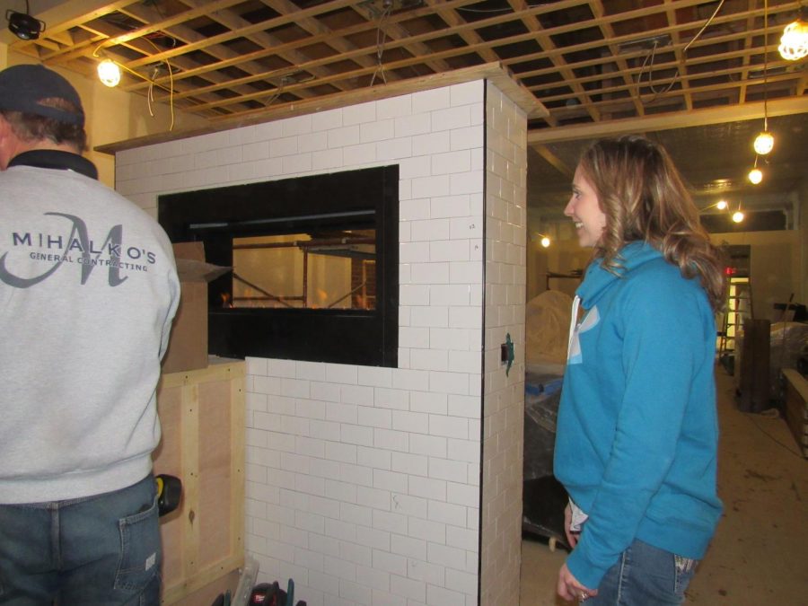 Balance Restaurant owner Amanda Artim shows off a fireplace built between bar and dining areas. 