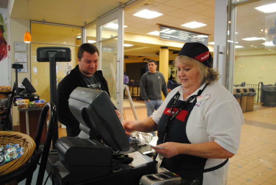 Senior Brady Willis pays Sodexo worker Lori Seigh for his food at the Tuck Shop.