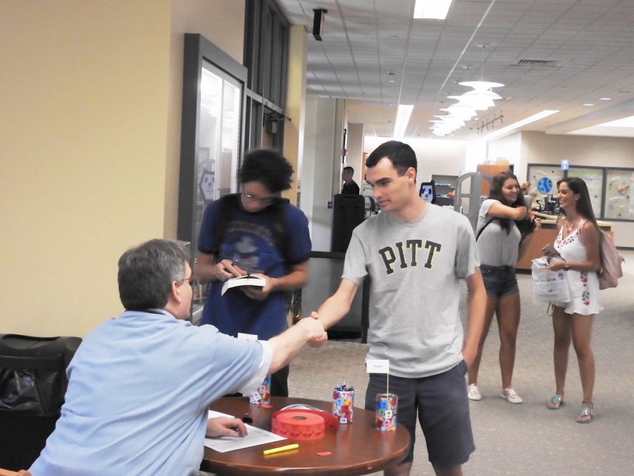 Sophomore Matt Stark shakes hands with Owen Library director Peter Egler at an Aug. 30 open house. Egler said that, eventually, all students will go through the personal-librarian program during their first year.
