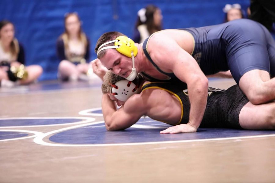 Junior+wrestler+Levi+Neibauer+scores+a+takedown+against+his+Millersville+opponent+on+Nov.+16+at+the+Sports+Center.+Neibauer+won+his+bout+in+a+3-0+decision%2C+and+contributed+to+the+wrestler%E2%80%99s+30-6+route+of+their+conference+rival.+