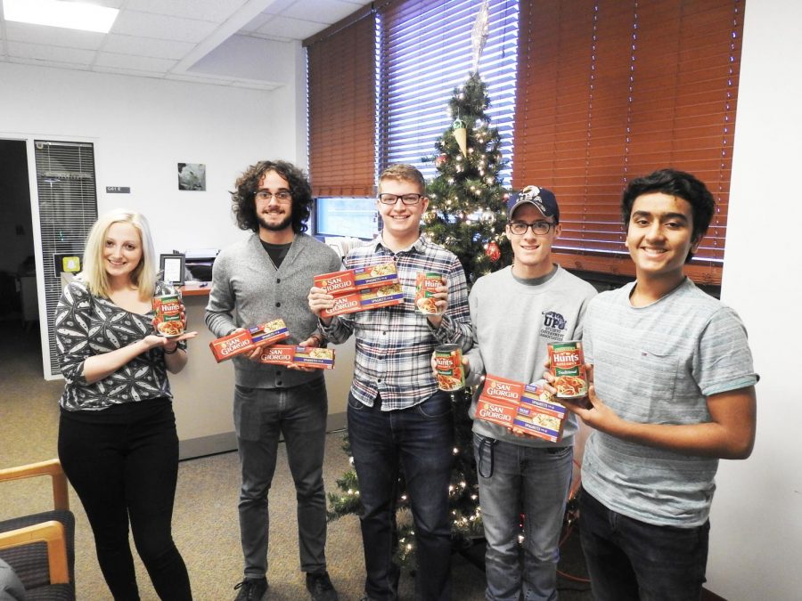 Student government members hold spaghetti noodles and pasta sauce in the Student Union. They are collecting donated goods to assist local families this Christmas. | Photo: Matt Churella