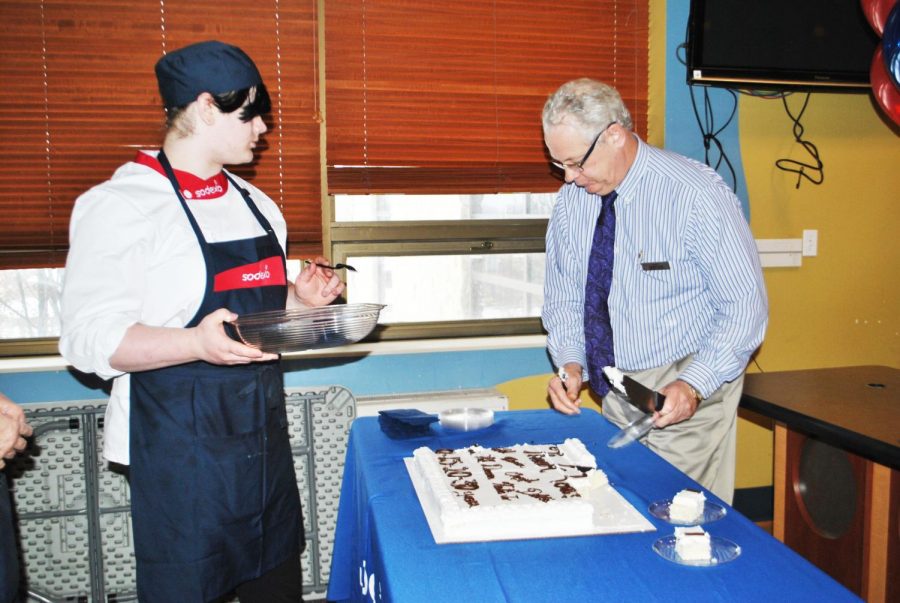 Sodexo General Manager Jim Butler (right) cuts a cake for a Sodexo staff celebration Feb. 11 in the Mt. Cat Club while Sodexo employee Solaris Deffenbaugh (left) waits for a piece.