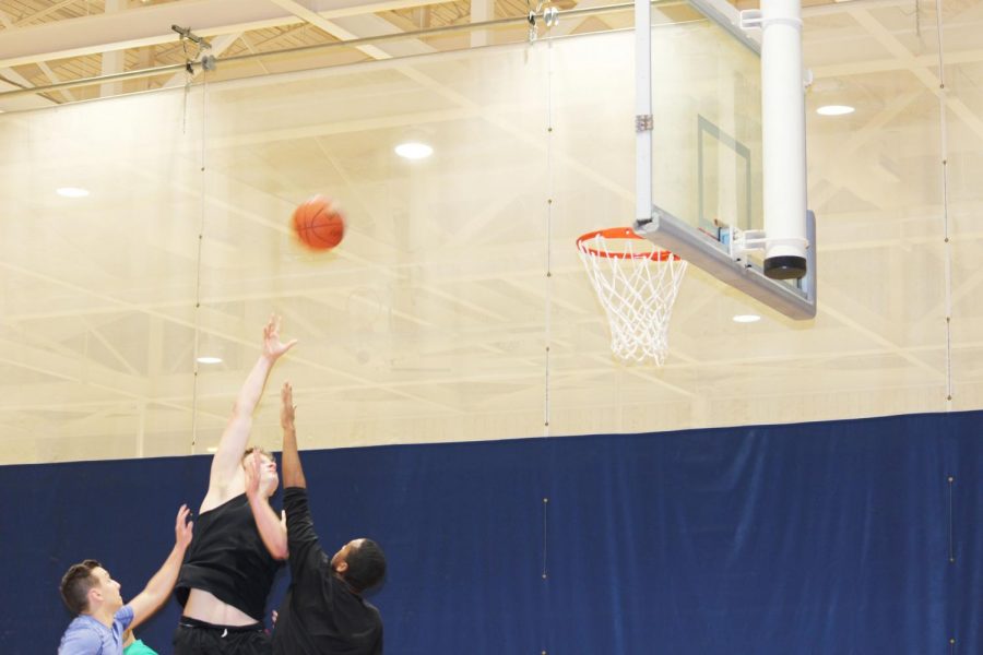 Matt Holsinger shoots the ball against two oppenents at the three vs three basketball helping Melo is Trash winning the game Jan. 28 in the Wellness Center.