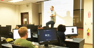 Writing Professor Eric Schwerer teaches his Intro to Professional Writing class Oct. 3. He said encourages students who are struggling academically.