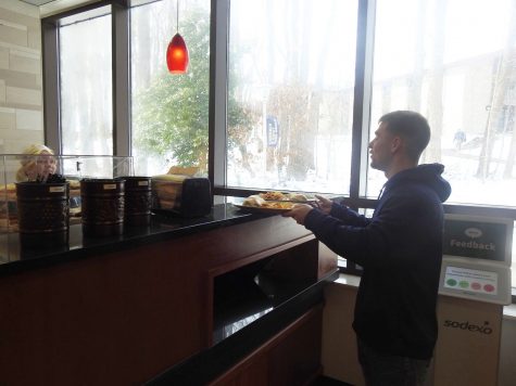 Senior Joe Romano picks up his food Jan. 9 at the Pitt Stop café where students can exchange one meal swipe per meal period for a combination of food options.