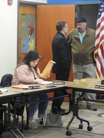 Freshman Hannah Ribblett prepares for a Jan. 9 Conemaugh Valley School Board meeting as Superintendent Shane Hazenstab (left) and board President Todd Roberts (right) have a conversation in the background.