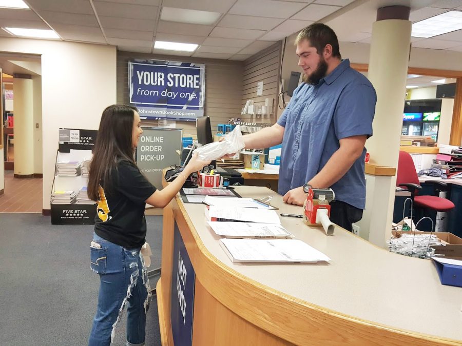 Book Center employee Sean Hitchens helped junior Lexi Weber complete a price match on Jan. 16 for her textbook purchase.